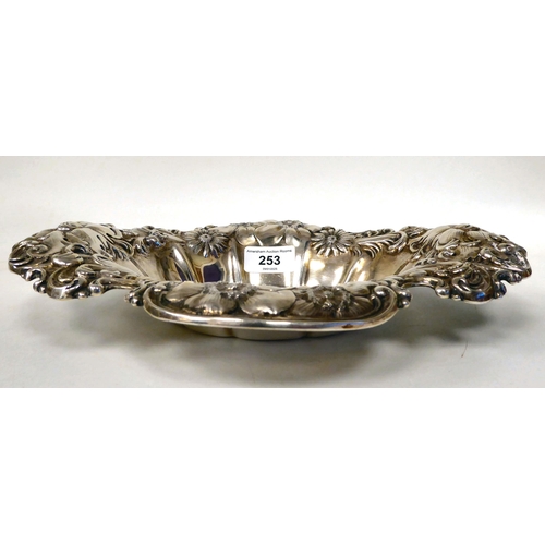 253 - A Sterling silver oval dish, the wide rim embossed with flora and scrolls  12