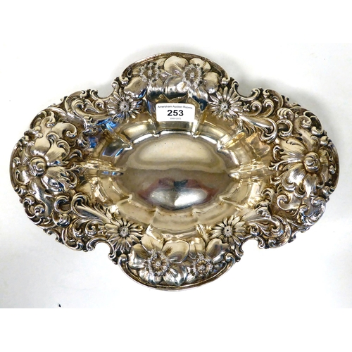 253 - A Sterling silver oval dish, the wide rim embossed with flora and scrolls  12