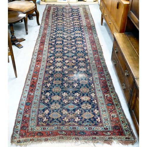 266 - An antique Persian runner, decorated with repeating floral designs, on a multi-coloured ground ... 