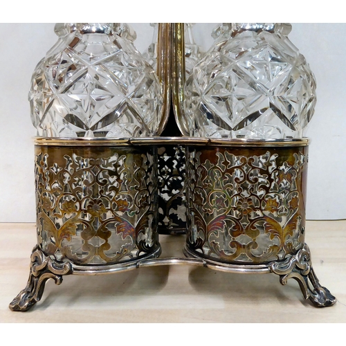 282 - An ornate cast silver plated cruet stand, hosting three glass decanters with stoppers