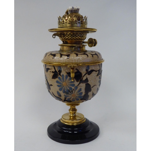 33 - A Royal Doulton two-part stoneware and brass table oil lamp, on a black glass pedestal base, decorat... 