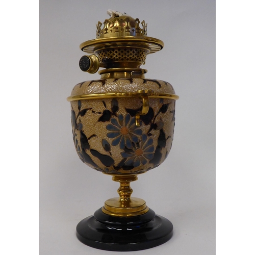 33 - A Royal Doulton two-part stoneware and brass table oil lamp, on a black glass pedestal base, decorat... 