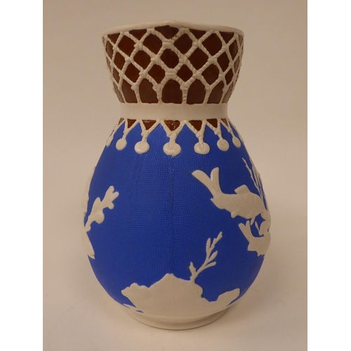 36 - A late 19thC cream, blue and chocolate coloured earthenware bulbous water jug, decorated in slip wit... 