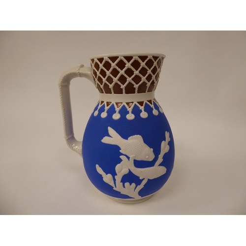 36 - A late 19thC cream, blue and chocolate coloured earthenware bulbous water jug, decorated in slip wit... 