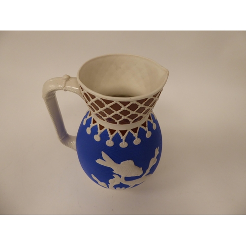 36 - A late 19thC cream, blue and chocolate coloured earthenware bulbous water jug, decorated in slip wit... 