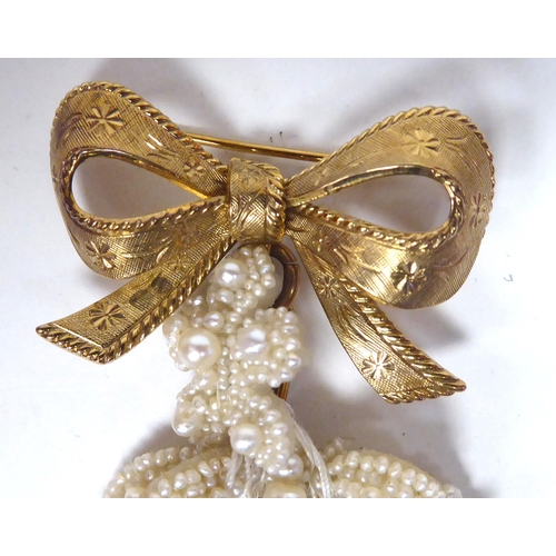 365 - An Edwardian style bespoke brooch, the 9ct gold ribbon design pin with a cluster of pearl droplets