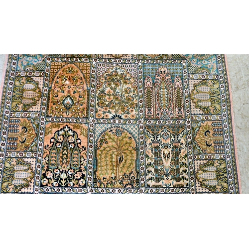 38 - A Persian part silk woven rug, decorated with pictorial boxes, on a multi-coloured ground and tassel... 