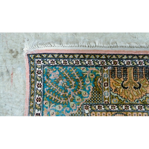 38 - A Persian part silk woven rug, decorated with pictorial boxes, on a multi-coloured ground and tassel... 