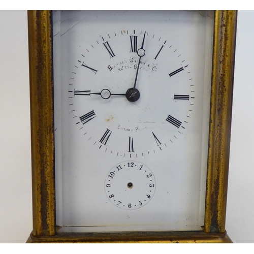 40 - A mid 20thC gilded brass cased carriage clock with bevelled glass panels and a folding top handle; t... 