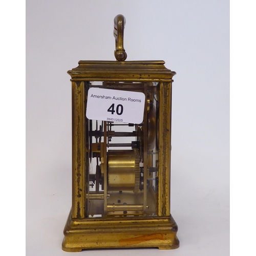 40 - A mid 20thC gilded brass cased carriage clock with bevelled glass panels and a folding top handle; t... 