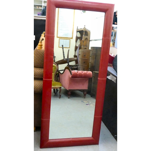 406 - A modern mirror with a red hide upholstered frame  70