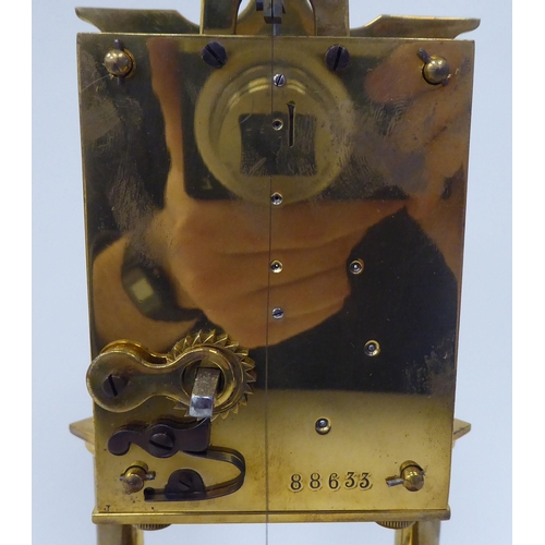 43 - An early 20thC lacquered brass cased torsion timepiece with an exposed mechanism, faced by a painted... 