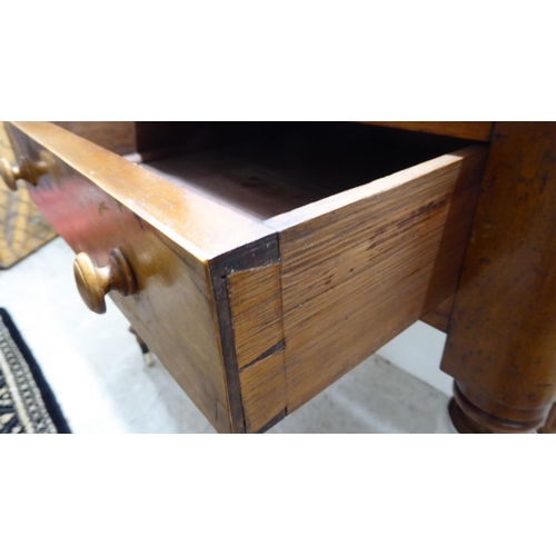 48 - A mid Victorian mahogany writing table with two side drawers, raised on reeded, tapered legs and cas... 