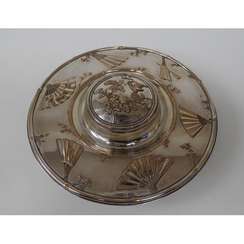 5 - A late Victorian Elkington & Co silver plated inkwell, the cut glass reservoir set in a saucer b... 