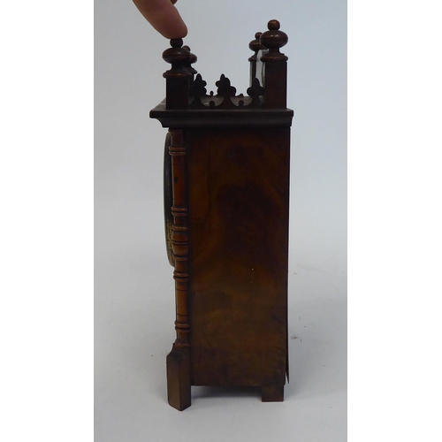 53 - A late 19thC walnut veneered cased mantel timepiece with turned, flank pilasters and a fretworked ga... 