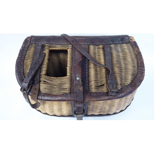 57 - A vintage wickerworked and stitched brown hide fishing creel with buckled straps