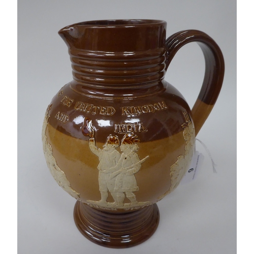 6 - A late 19thC two tone brown stoneware jug of bulbous form with a ribbed neck and pedestal foot, deco... 