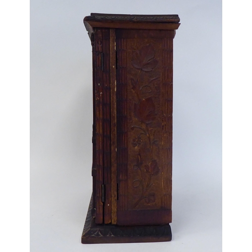 60 - An early 20thC Continental, probably German, limewood, table-top cabinet, carved with organic design... 