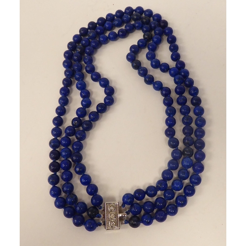 65 - A modern lapis lazuli coloured suite of jewellery, viz. a triple row necklace, a bracelet, ring and ... 