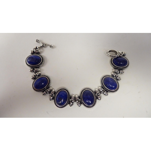 65 - A modern lapis lazuli coloured suite of jewellery, viz. a triple row necklace, a bracelet, ring and ... 