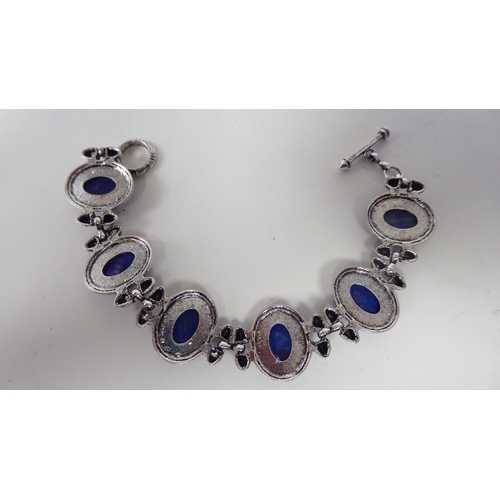 65 - A modern lapis lazuli coloured suite of jewellery, viz. a triple row necklace, a bracelet, ring and ... 