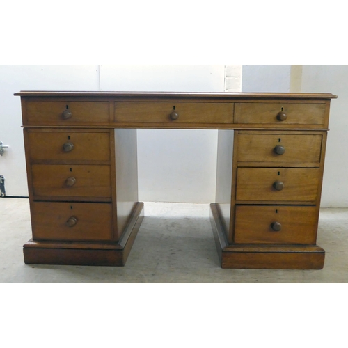 70 - A late Victorian mahogany nine drawer, twin pedestal desk, on a plinth  28