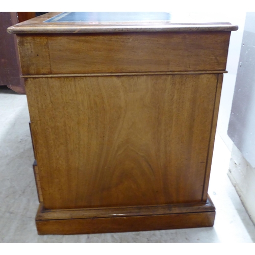 70 - A late Victorian mahogany nine drawer, twin pedestal desk, on a plinth  28