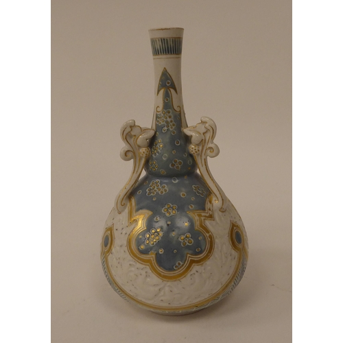 71 - A late 19thC Doulton Lambeth Carrara stoneware bottle vase with applied handles, decorated in tones ... 