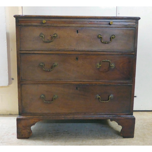 74 - A George III crossbanded mahogany bachelor's chest with a brushing slide, over three drawers, raised... 