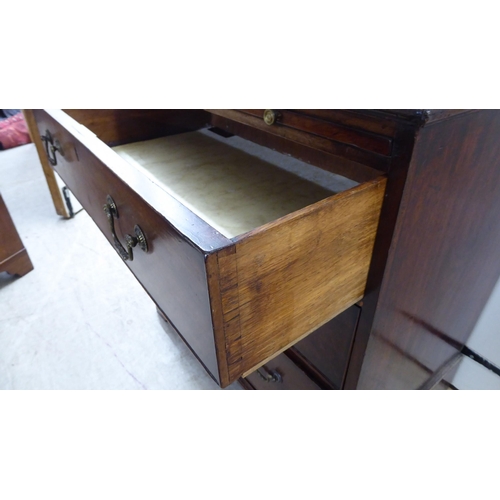 74 - A George III crossbanded mahogany bachelor's chest with a brushing slide, over three drawers, raised... 