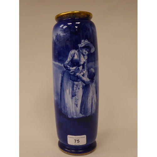 75 - An early 20thC Royal Doulton china cylindrical vase, decorated in blue and white with a woman and ch... 