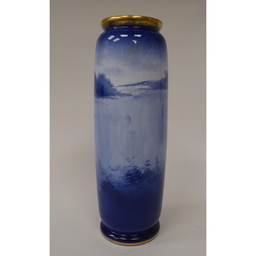 75 - An early 20thC Royal Doulton china cylindrical vase, decorated in blue and white with a woman and ch... 