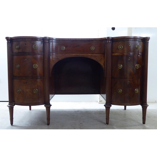 76 - An Edwardian string inlaid mahogany, one piece breakfront kneehole sideboard with an arrangement of ... 