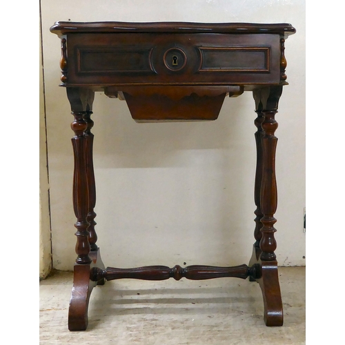 8 - A late Victorian mahogany work table with a serpentine outlined, hinged lid, over reeded pillar supp... 