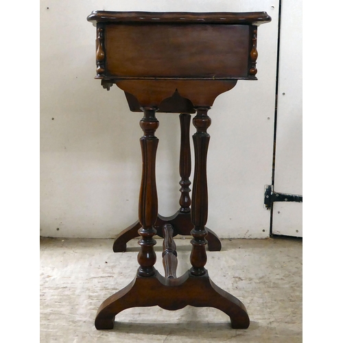 8 - A late Victorian mahogany work table with a serpentine outlined, hinged lid, over reeded pillar supp... 