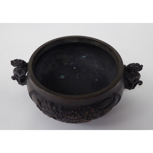 88 - A 19thC Chinese bronze censer with twin heraldic iron handles, decorated with floral vignettes  bear... 