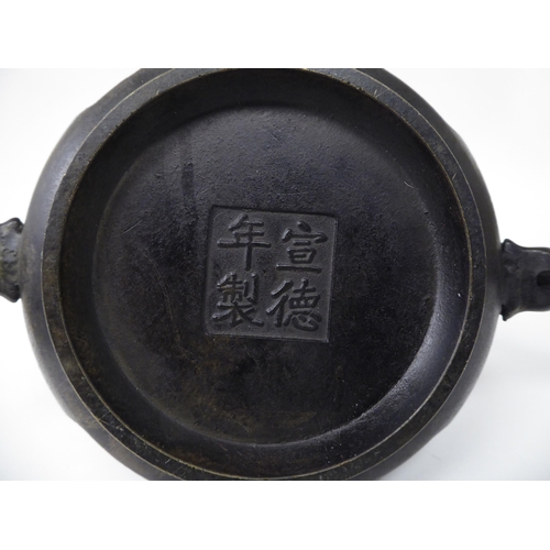 88 - A 19thC Chinese bronze censer with twin heraldic iron handles, decorated with floral vignettes  bear... 