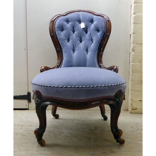 92 - A late Victorian mahogany showwood framed and part-button upholstered nursing chair, raised on carve... 