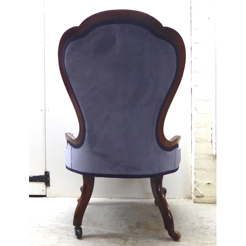 92 - A late Victorian mahogany showwood framed and part-button upholstered nursing chair, raised on carve... 