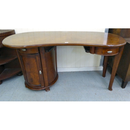 398 - A modern mahogany finished kidney shaped desk with twin pedestal, one with a drawer, the other, a dr... 