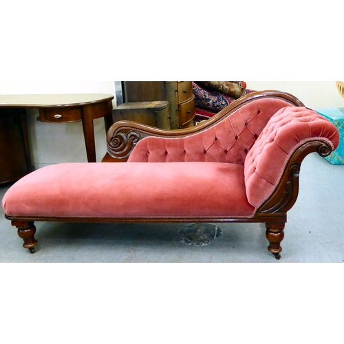 62 - A late Victorian mahogany framed chaise lounge, upholstered in a maroon coloured fabric, raised on t... 