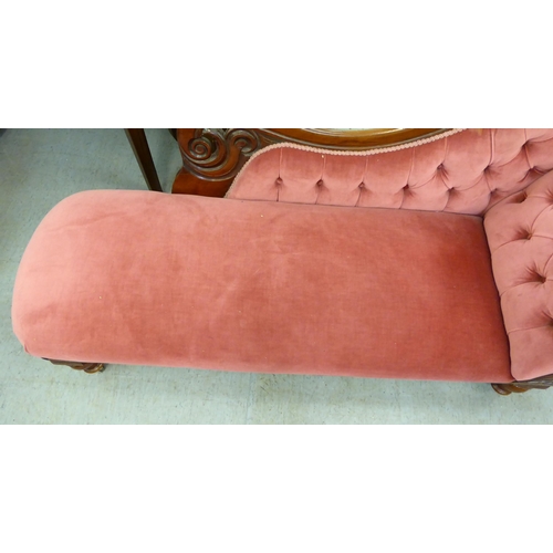 62 - A late Victorian mahogany framed chaise lounge, upholstered in a maroon coloured fabric, raised on t... 