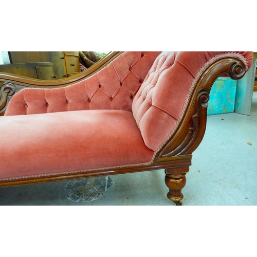 62 - A late Victorian mahogany framed chaise lounge, upholstered in a maroon coloured fabric, raised on t... 