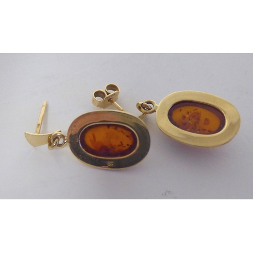 276 - A pair of 14ct gold, amber set earrings; and a similar pair of 9ct gold