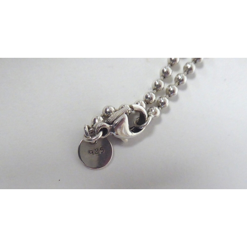 286 - A Tiffany & Co silver dog tag pendant with engraved decoration, on a ring link neckchain