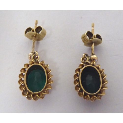 288 - A pair of 9ct gold, oval, emerald set pendant earrings