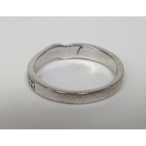 296 - An 18ct white gold and diamond set, eyebrow band ring