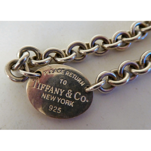 377 - A Tiffany Sterling silver ring link necklet; and matching bracelet with engraved oval dog tags and c... 