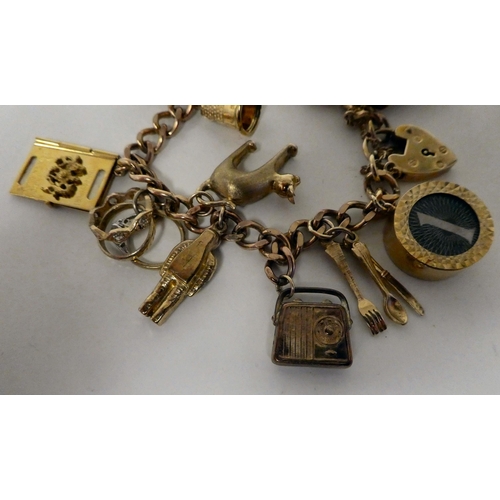 4 - A 9ct gold charm bracelet with various charms, including 10/- and £1 notes