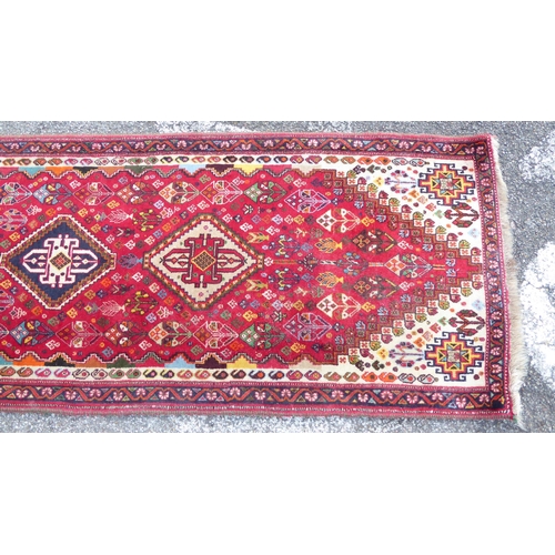 67 - A Persian style runner, decorated with central diamond formations, surrounded by stylised designs, o... 